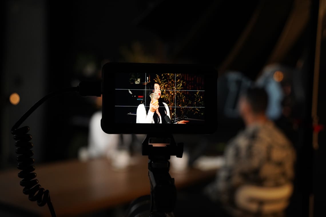 A camera monitor framing a guest mid-answer in the Put Out Content studio